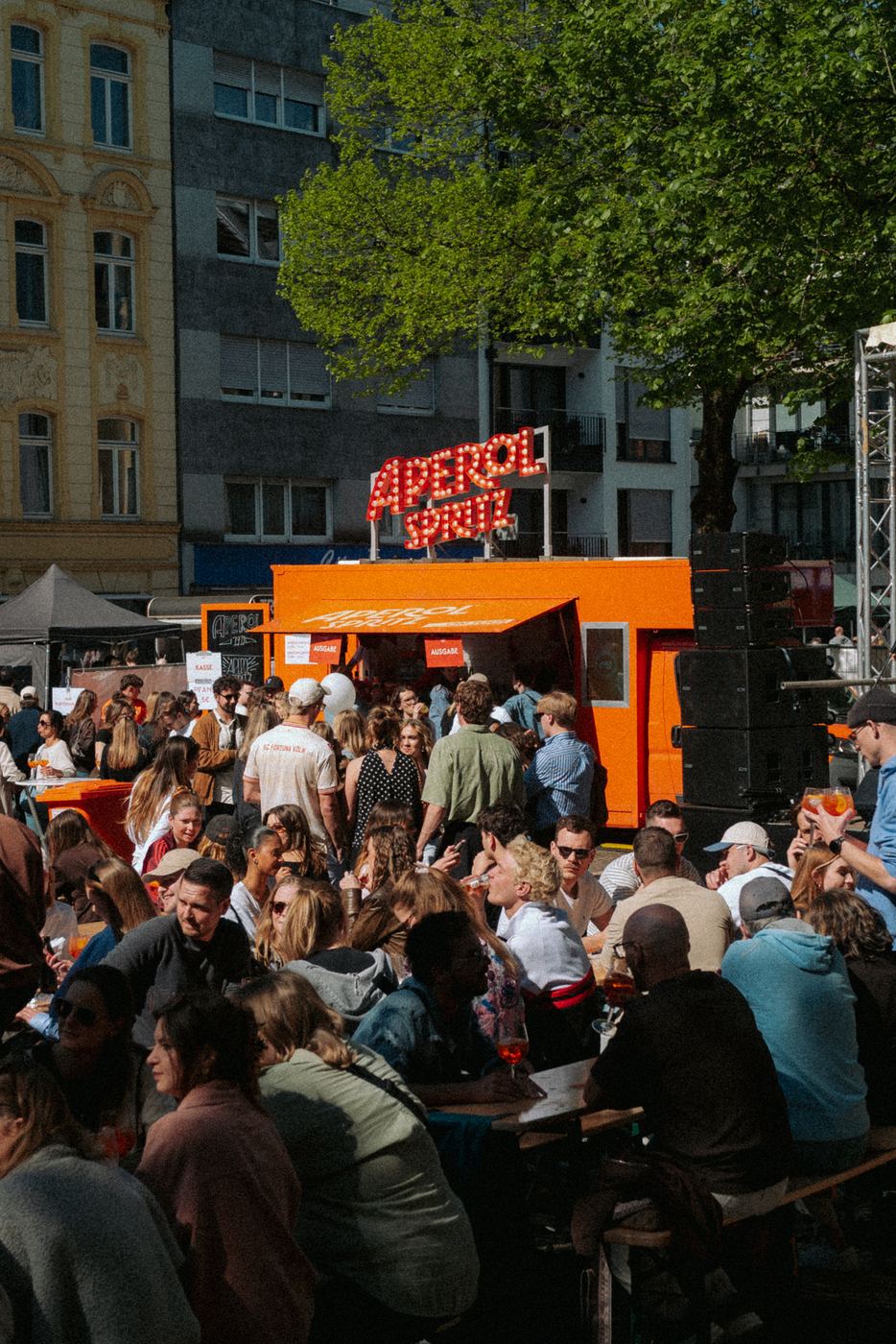 Volle Bierbänke vor dem Aperol Truck