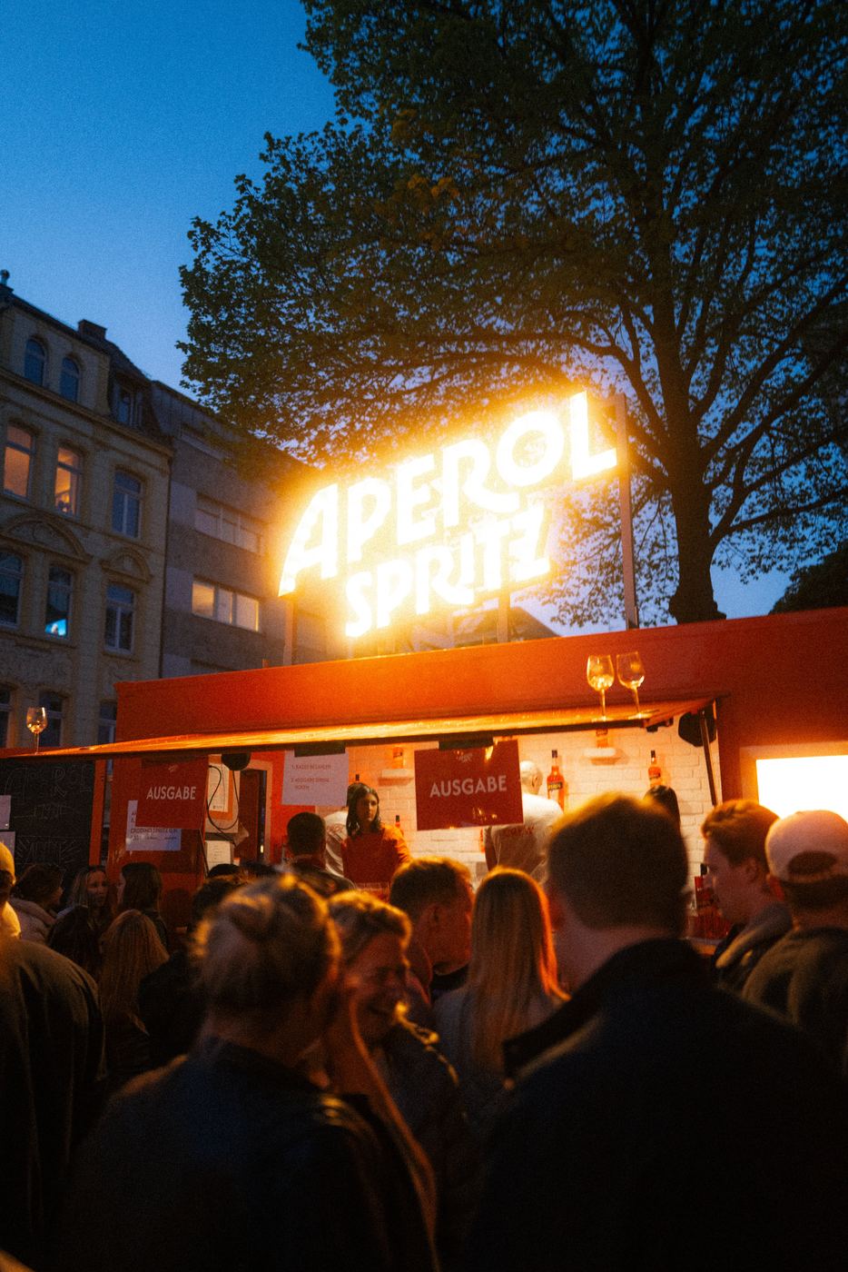 Leuchtende Aperol-Schrift am Abend