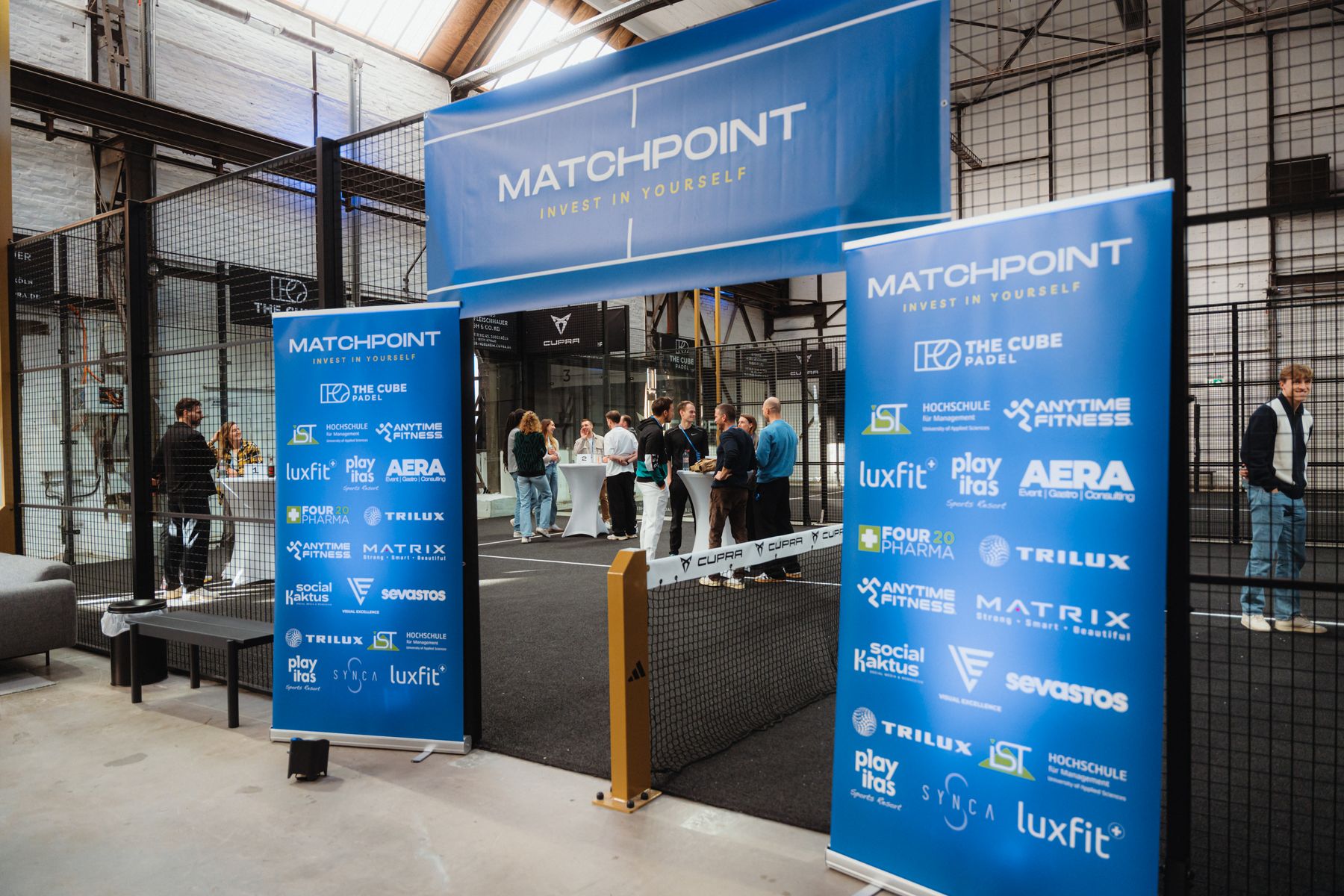 Eingang zu Matchpoint mit Banner und Padel-Court