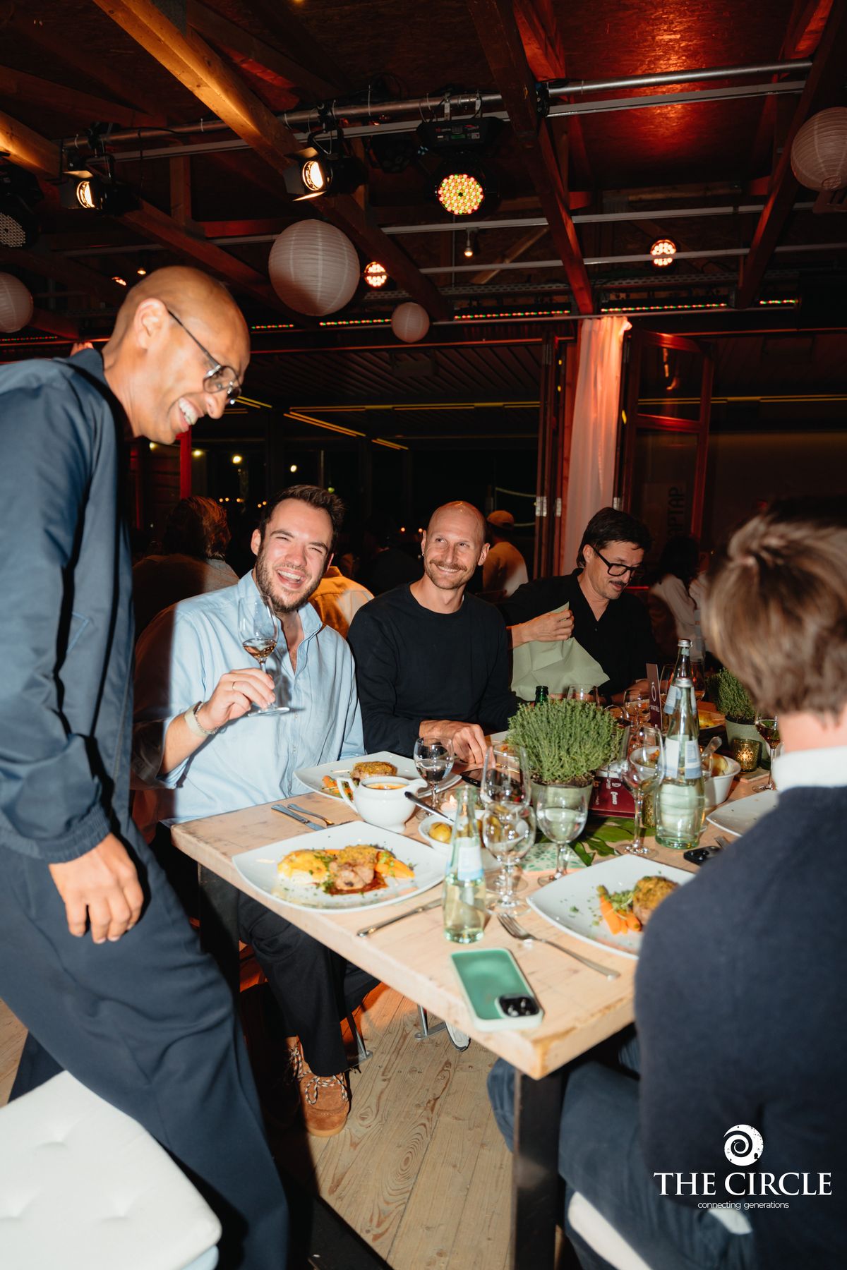 Gäste lachen gemeinsam am Tisch beim Netzwerk-Abend The Circle